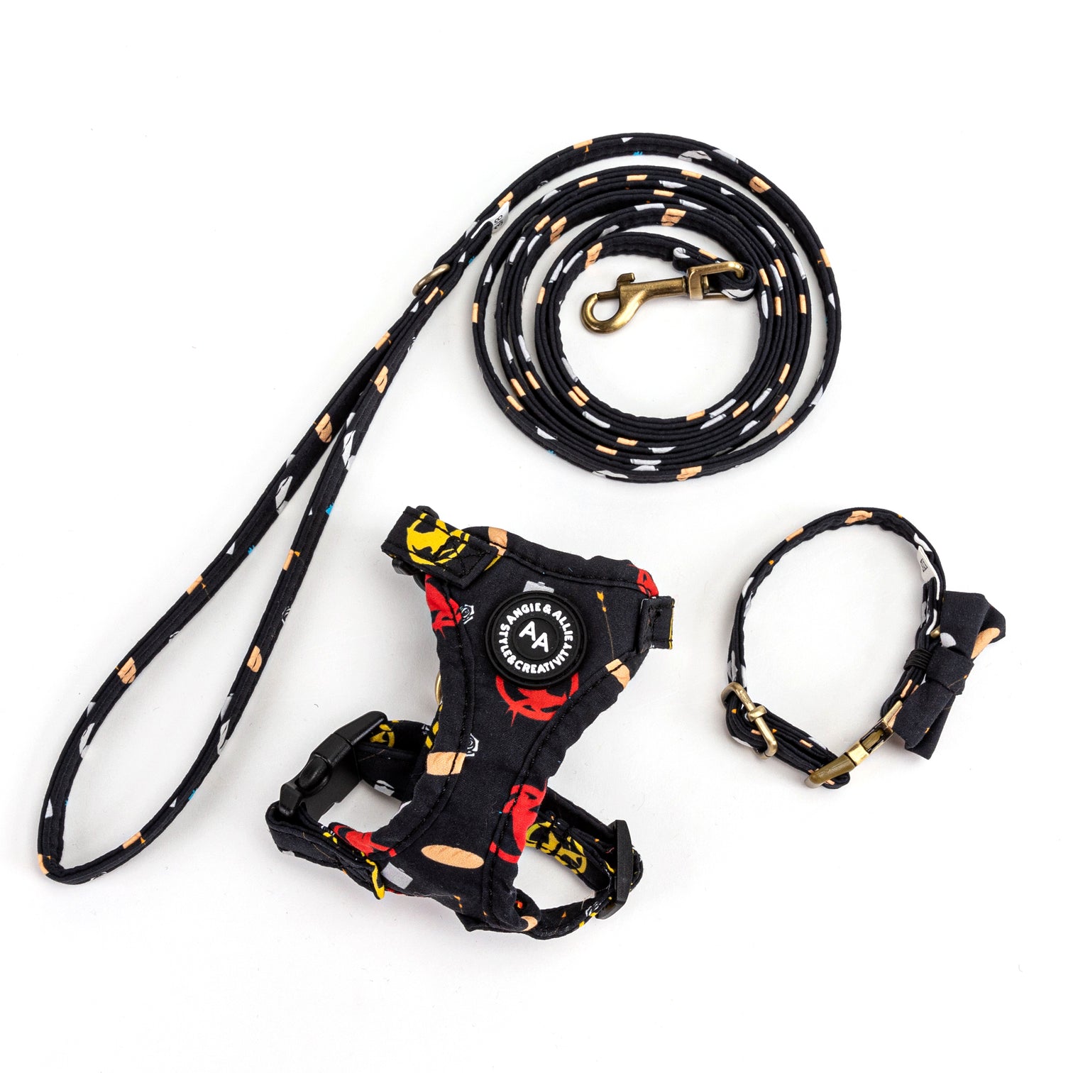A black dog harness set with colorful patterns, featuring a leash, harness, and collar. The leash has a bronze clasp.